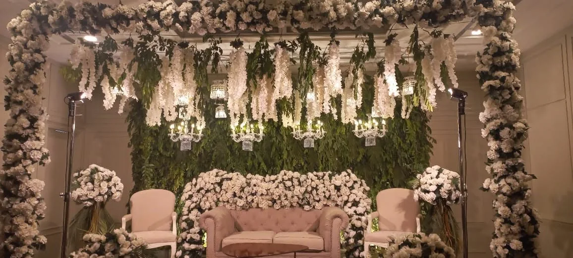 White floral wedding stage with hanging chandeliers